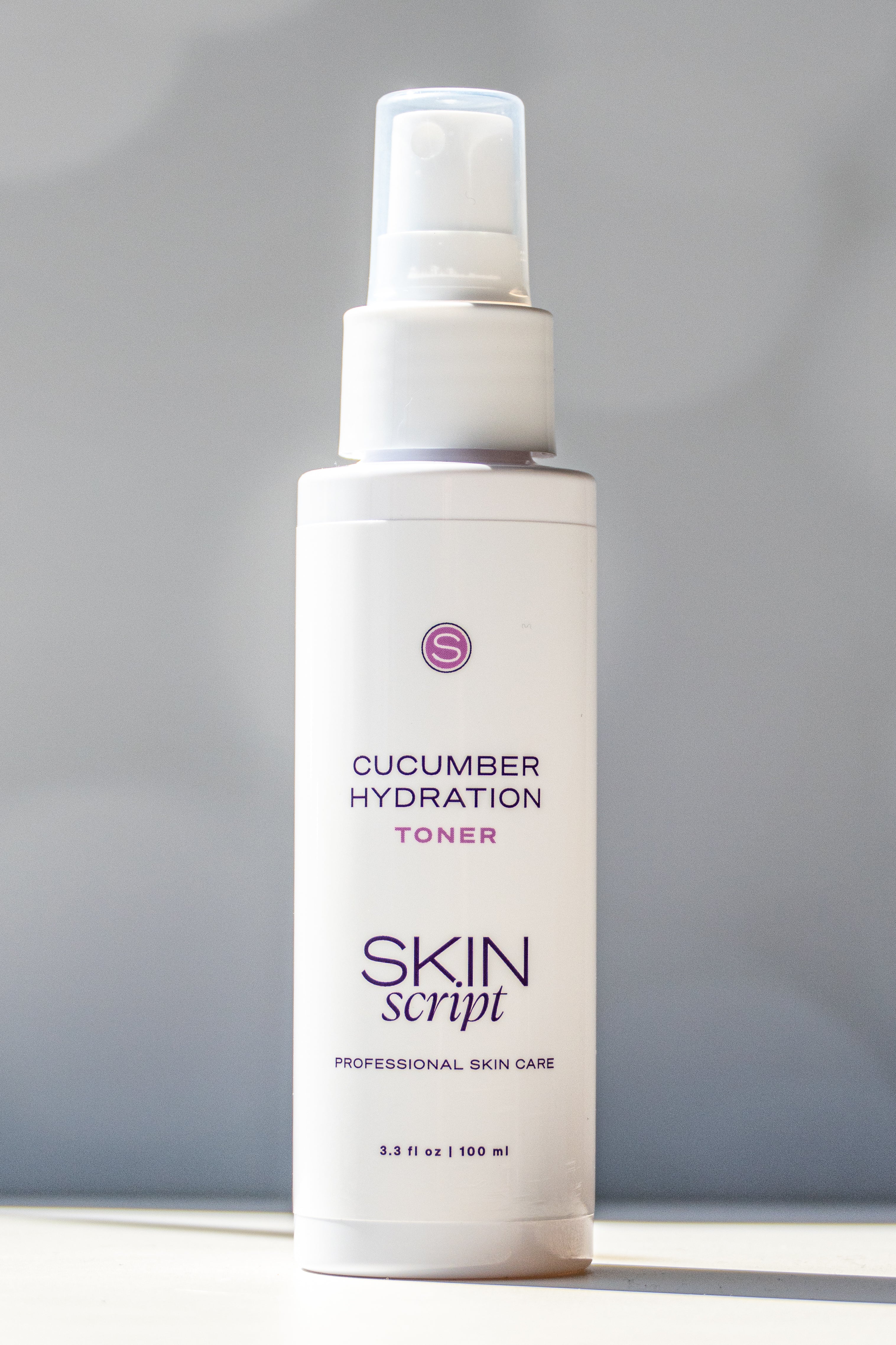 Skincare toner bottle labeled 'Cucumber Hydration Toner' by 'Skin Script' on a gray background