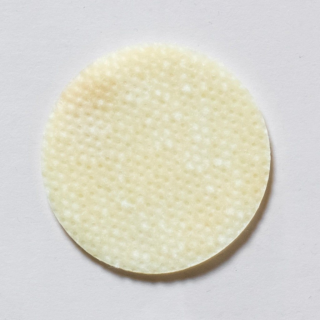 Round, beige adhesive patch on a light gray background